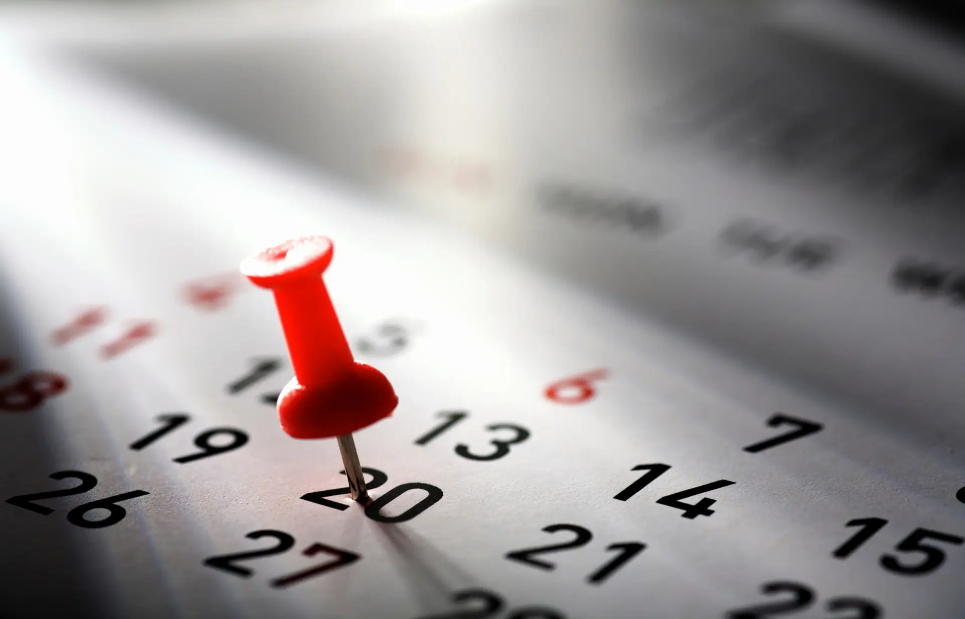 Illustration of a red pushpin marking an important date on a calendar.