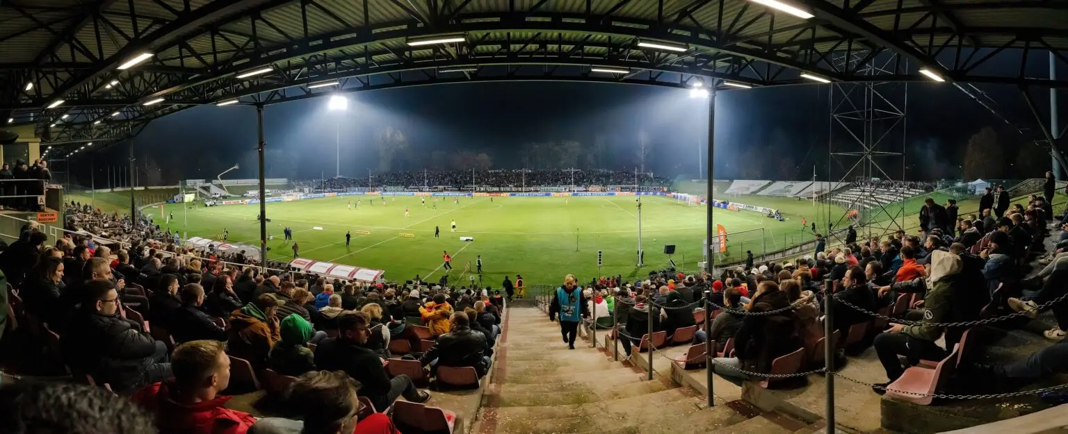 Partido de fútbol de noche bajo los reflectores del estadio