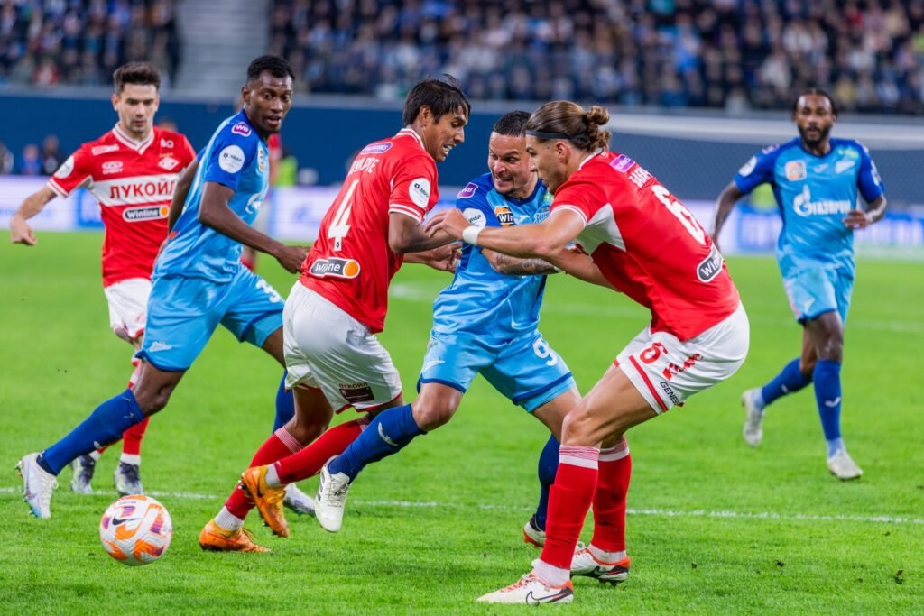Jugadores disputando el balón en un partido de liga profesional de fútbol